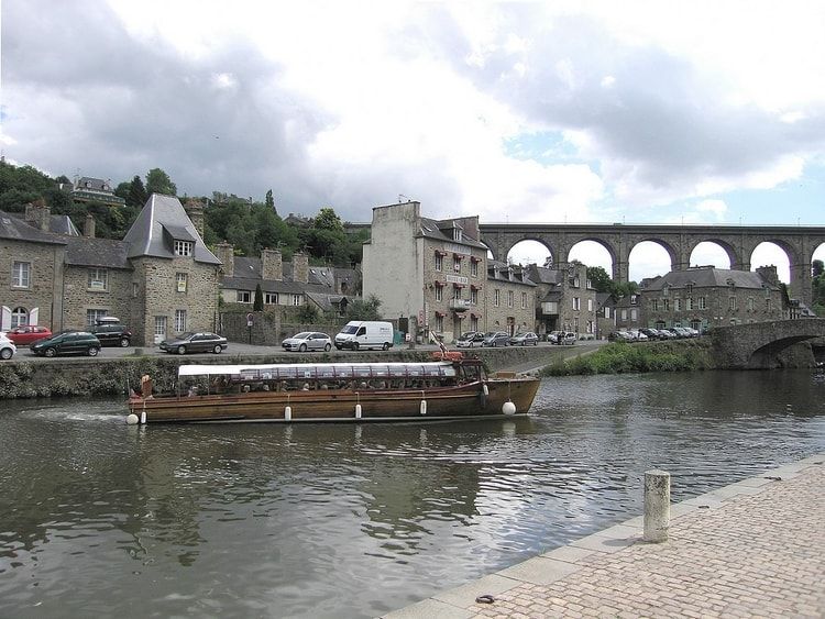 Bateau naviguant sur rivière avec pont en arrière-plan.
