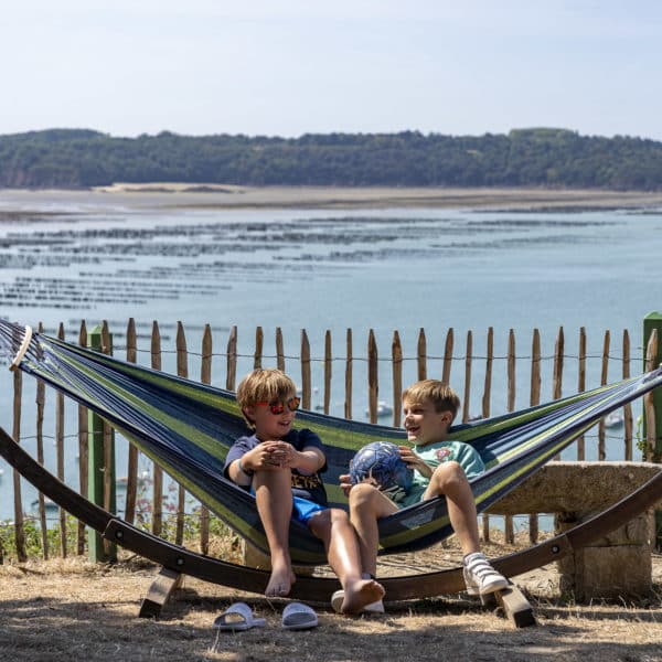Deux enfants dans un hamac dos à l'océan 